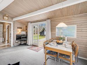 Un comedor con mesa y sillas y un televisor. en Holiday Home Leandra - 11km from the sea by Interhome, en Dyreby