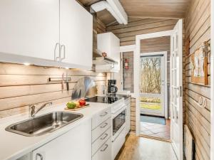 Una cocina con gabinetes blancos y un fregadero. en Holiday Home Leandra - 11km from the sea by Interhome, en Dyreby