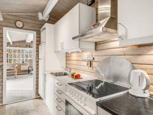 Una cocina con gabinetes blancos y un fregadero. en Holiday Home Leandra - 11km from the sea by Interhome, en Dyreby 17 fotos más