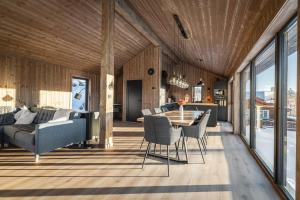 una sala de estar con una mesa y un sofá en New luxury cabin in Geilo with hot tub, mountain views & ski access, en Lii