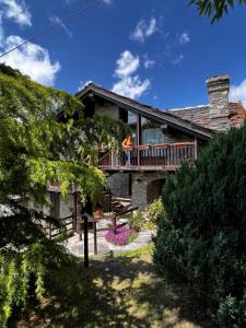 a house with a deck with two people on it at Chalet Cheverel (AO) in Remondey