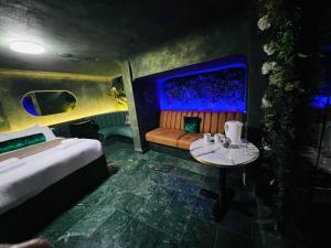 a room with a bed and a couch and a table at Paragraph Tottenham in Southgate