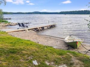 a boat is parked at a dock on a lake at Holiday Home Nurmirinne by Interhome in Nurmes
