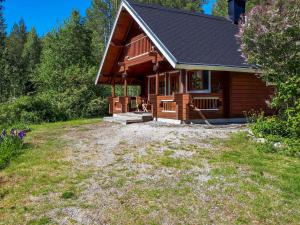 a log cabin with a large yard in front of it at Holiday Home Nurmirinne by Interhome in Nurmes