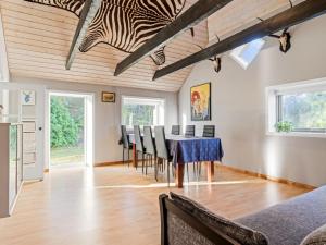 a kitchen and dining room with a table and chairs at Holiday Home Emelia - 4-2km from the sea by Interhome in Byrum
