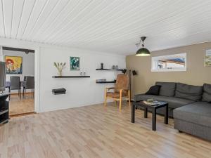 a living room with a couch and a table at Holiday Home Emelia - 4-2km from the sea by Interhome in Byrum
