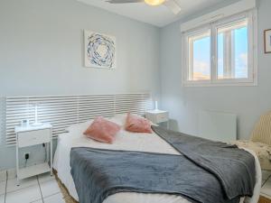 Apartment Les Hauts de la Corniche by Interhome في ميميزا-بلاج: غرفة نوم مع سرير مع وسادتين ورديتين عليه