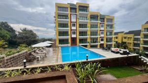 a hotel with a swimming pool and a building at Nisarg in Canacona