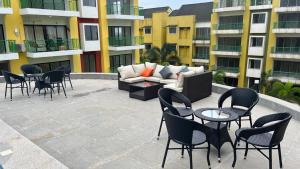 a patio with chairs and a couch and tables at Nisarg in Canacona