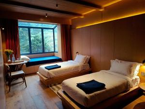 The Himalayan Tyangboche في Lukla: غرفة فندق بها سريران ونافذة