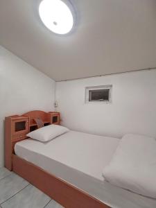 a bedroom with a bed and a small window at Townhome 45 in Ban Nong Pru