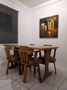 a wooden table and chairs in a room with a painting at Townhome 45 in Ban Nong Pru +3 photos