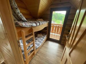 Bali domy RESTORT & SPA في Laskowa: غرفة صغيرة مع سرير بطابقين في كابينة