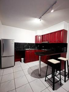 a kitchen with red cabinets and a table and a refrigerator at Townhome 45 in Ban Nong Pru