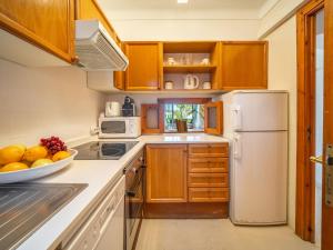a kitchen with wooden cabinets and a bowl of fruit on the counter at Apartment Carabela Chic by Interhome in Alcudia