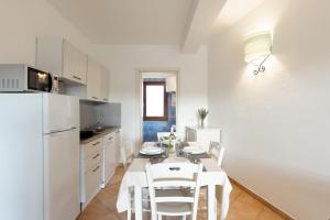 a kitchen and dining room with a table and chairs at Baia dei Mirti 4 people Apartment in Vignola Mare