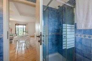 a bathroom with a shower with blue tiles at Baia dei Mirti 4 people Apartment in Vignola Mare