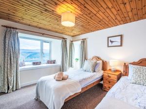 Holiday Home Bunloit Farmhouse by Interhome في Inverfarigaig: غرفة نوم بها سريرين ونافذة +27 صورة