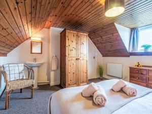 Holiday Home Bunloit Farmhouse by Interhome في Inverfarigaig: غرفة نوم بسرير وكرسي ومغسلة