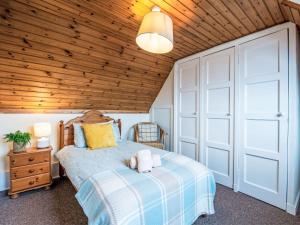 Holiday Home Bunloit Farmhouse by Interhome في Inverfarigaig: غرفة نوم بها سرير وسقف خشبي