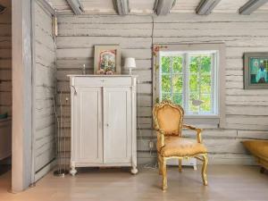 Holiday Home Den lilla röda stugan by Interhome في Kårkulla: غرفة بها كرسي وخزانة ونافذة
