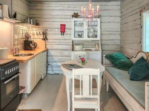 Holiday Home Den lilla röda stugan by Interhome في Kårkulla: مطبخ مع طاولة مع لاب توب عليها