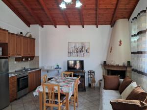 a kitchen and living room with a table and a couch at Krista House in Agios Gordios