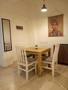 uma sala de jantar com mesa e cadeiras de madeira em Apartment GARDEN 1 CENTER em Novi Sad