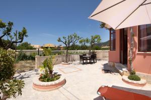 a patio with a table and an umbrella at Krista House in Agios Gordios