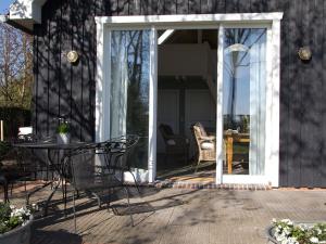 een open patiodeur met een tafel en stoelen bij Ferienhaus Clara in Klein Scharrel