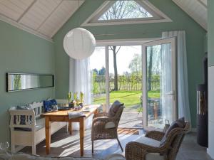 een woonkamer met een tafel en stoelen en een raam bij Ferienhaus Clara in Klein Scharrel