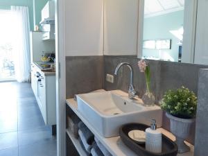 een badkamer met een wastafel en een spiegel bij Ferienhaus Clara in Klein Scharrel