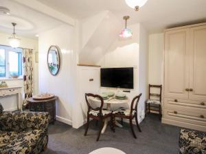 Bumble Bee at 2 Clematis Cottage في Hopton Wafers: غرفة معيشة مع طاولة وتلفزيون