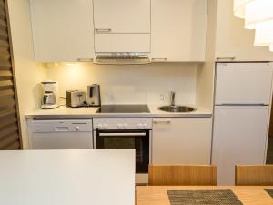 Holiday Home Nordic chalet 8202 by Interhome في يلاس: مطبخ صغير بخزائن بيضاء ومغسلة