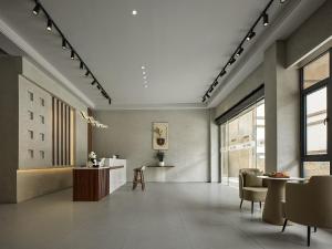 una sala de estar con una mesa y sillas en Zhangjiajie JoyMaple Hotel, en Zhangjiajie