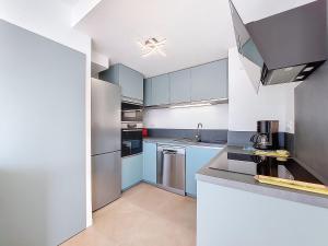 a kitchen with stainless steel appliances and blue cabinets at Apartment Veleda by Interhome in La Palmyre