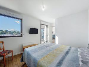 a white bedroom with a bed and a window at Apartment Veleda by Interhome in La Palmyre