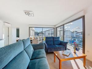 a living room with two blue couches and a table at Apartment Veleda by Interhome in La Palmyre