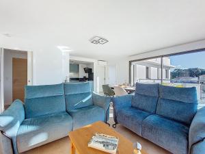 a living room with two blue couches and a table at Apartment Veleda by Interhome in La Palmyre
