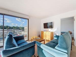 a living room with two blue couches and a large window at Apartment Veleda by Interhome in La Palmyre +24 photos