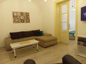 uma sala de estar com um sofá e uma mesa de centro em Apartment GARDEN 1 CENTER em Novi Sad