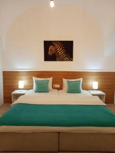 um quarto com uma cama grande e uma pintura de zebra na parede em Apartment GARDEN 1 CENTER em Novi Sad