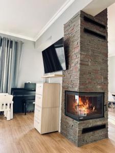 ein Wohnzimmer mit einem gemauerten Kamin und einem TV in der Unterkunft Holiday Home in Dejani