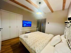 ein Schlafzimmer mit einem Bett und einem Fernseher an der Wand in der Unterkunft Holiday Home in Dejani