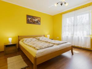 a bedroom with a bed with yellow walls and a window at Apartment Pajtas 2 by Interhome in Balatonfenyves