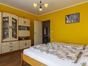 a bedroom with a bed and a yellow wall at Apartment Pajtas 2 by Interhome in Balatonfenyves +24 photos
