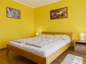 a bedroom with a bed with yellow walls at Apartment Pajtas 2 by Interhome in Balatonfenyves