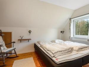 a bed in a room with a window and a chair at Holiday Home Paule - 1-3km from the sea by Interhome in Vesterø Havn