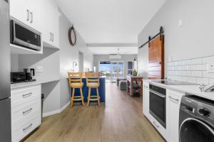 a kitchen with white cabinets and wooden floors at 10 Gleneagles, Salt Rock in Ballito