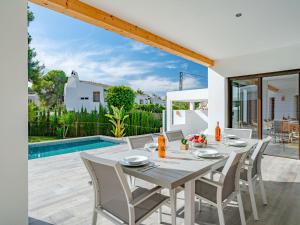 - une salle à manger avec une table et des chaises à côté de la piscine dans l'établissement Villa Can Calablanca by Interhome, à El Tosalet